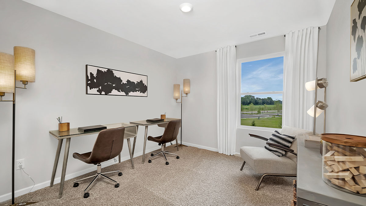 bedroom with two desks and a window with white curtains