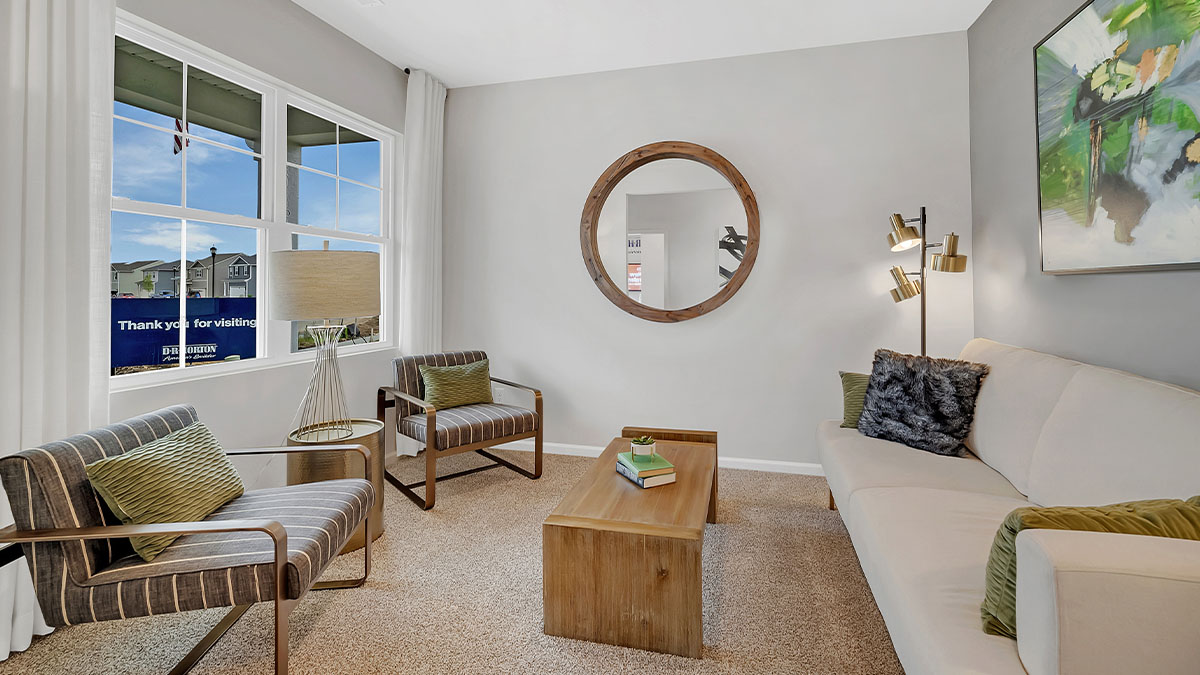 Entry way den with a white sofa and two grey accent chairs