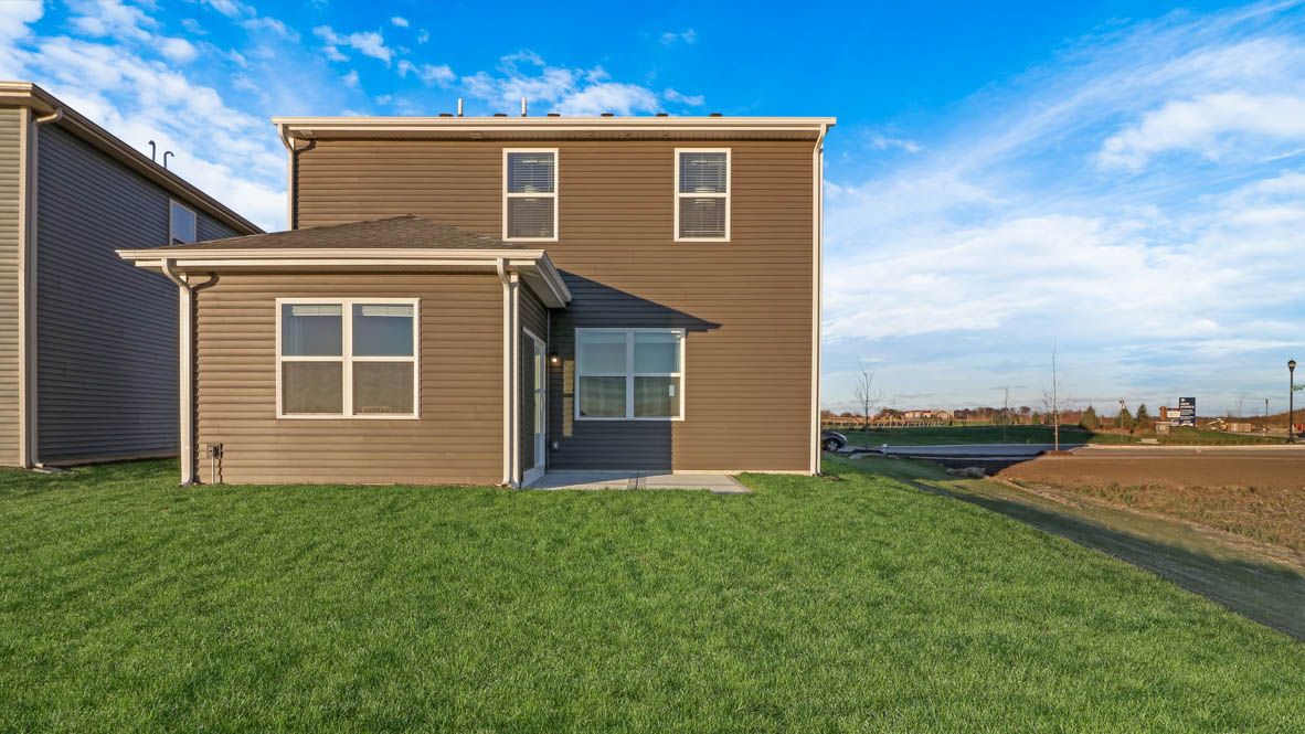 exterior backside of the home with lush green grass