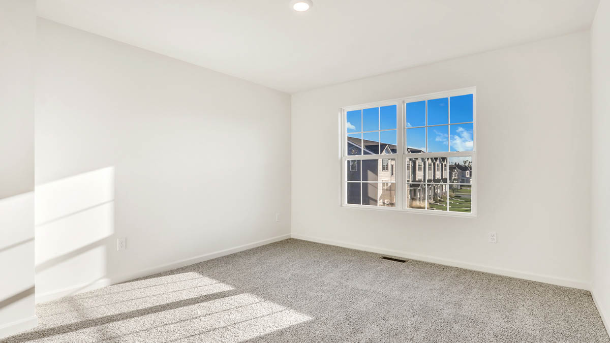 Primary bedroom features ample space, double windows, soft carpet, a stylish walk-in closet, and a private ensuite bath