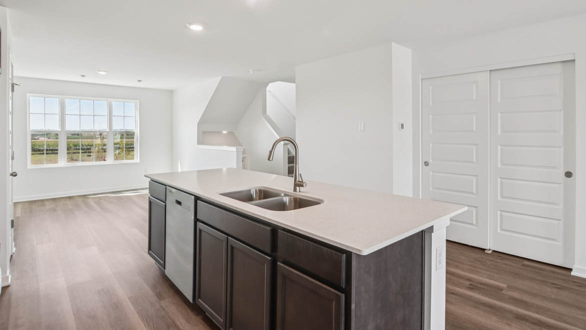Central kitchen island anchors the home adding a dining option, full sink, pantry and storage, multi-prep zones