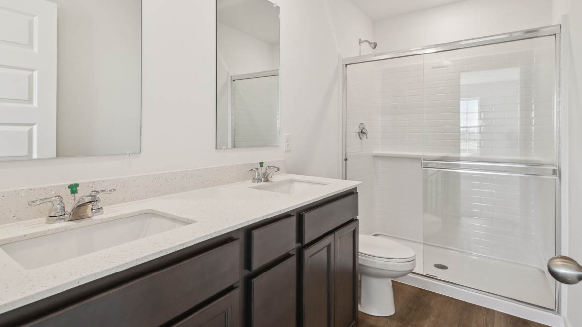 Primary ensuite in D.R. Horton's new townhome adds stylish touches, vanity with dual sinks, shower, tub, walk-in closet