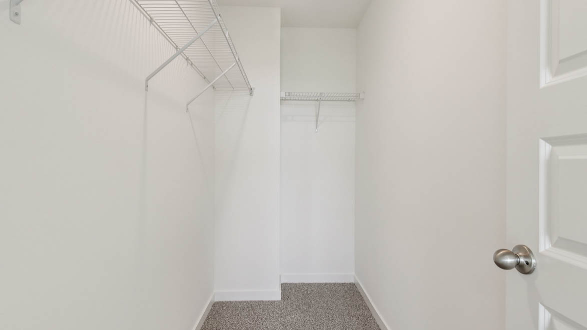 Primary walk-in wardrobe in our new build townhome adds stylish storage and built-in space