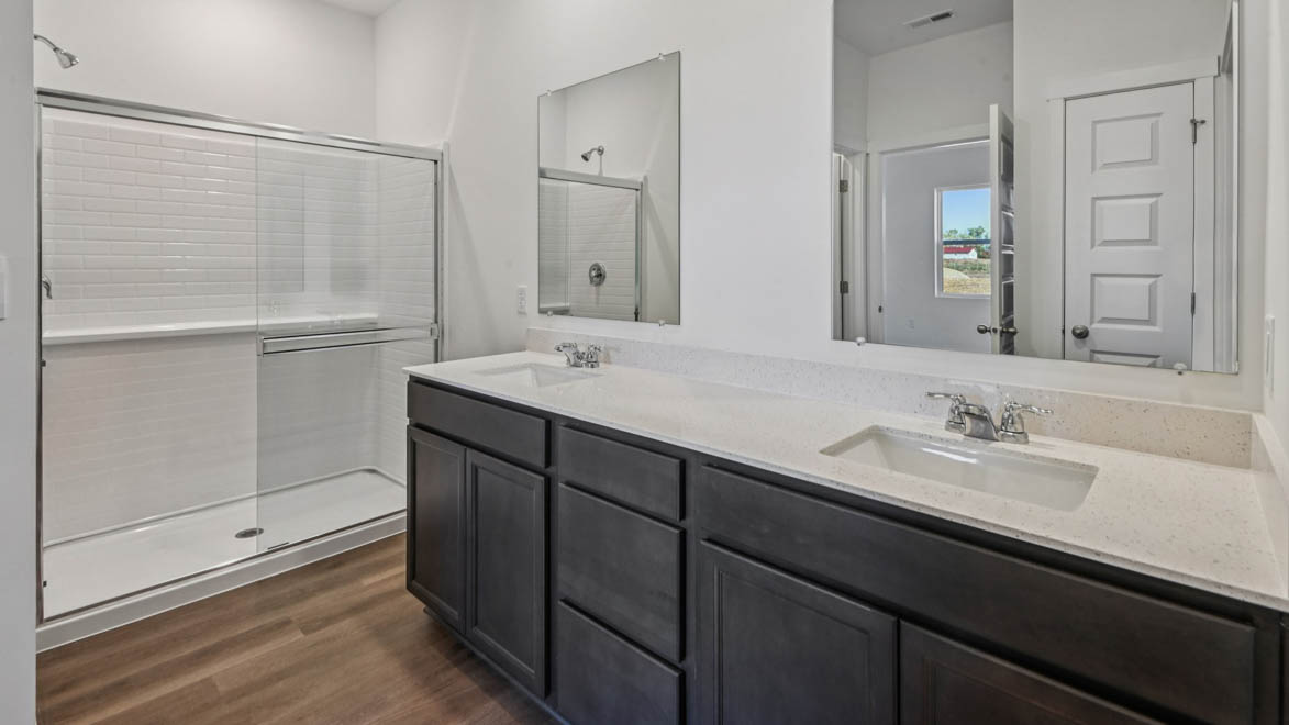 Primary bathroom with dual sinks and walk in shower