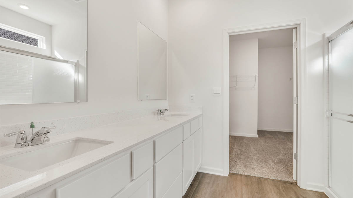 primary bathroom with dual sinks and walk in shower