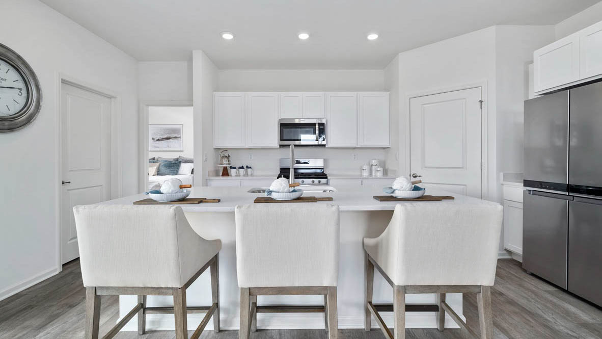 Spacious kitchen with white cabinets and white quartz countertops