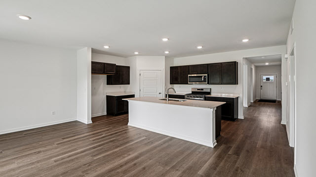 Interior kitchen with center island and dark cabinets