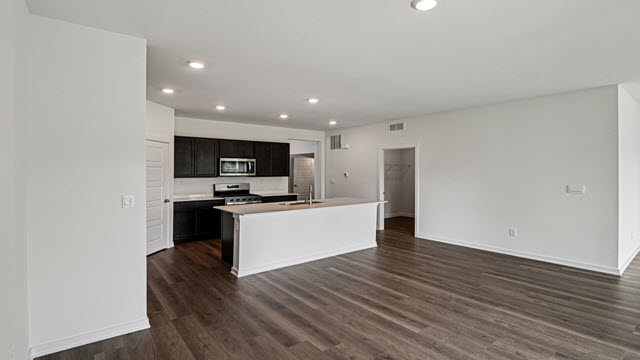 Interior kitchen with center island and dark cabinets