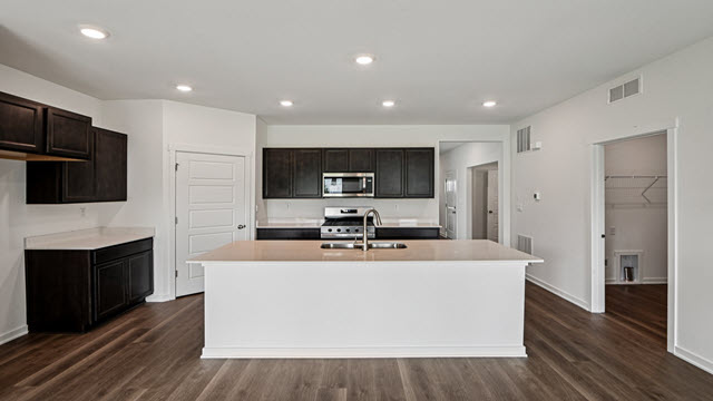 Interior kitchen with center island and dark cabinets