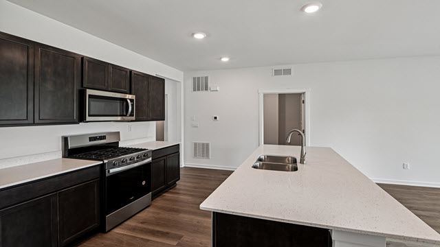 Interior kitchen with center island and dark cabinets