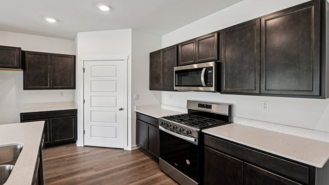 Interior kitchen with center island and dark cabinets