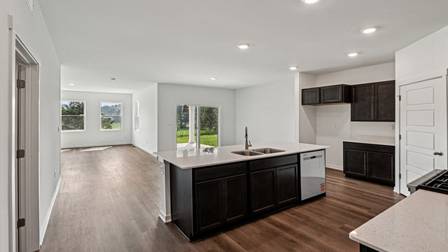 Interior kitchen with center island and dark cabinets