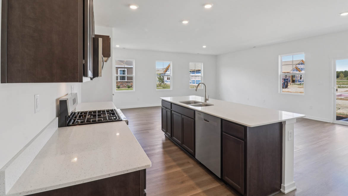 Kitchen along back wall with dark cabinets and white quartz countertops