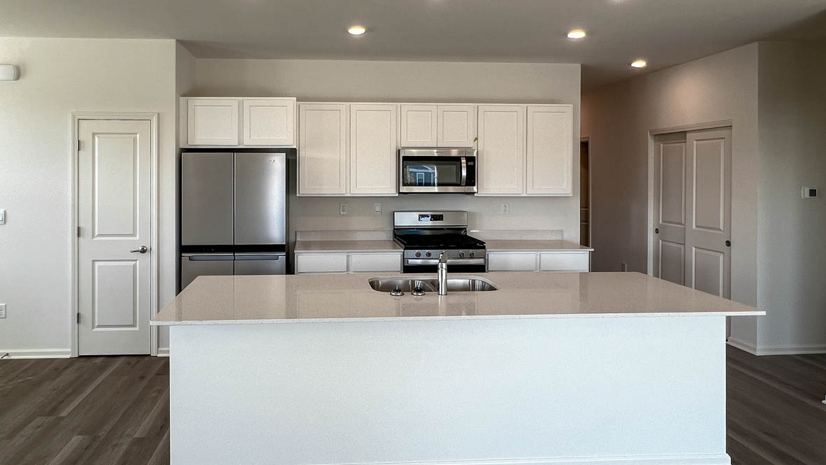 Kitchen with white cabinets and white quartz countertops