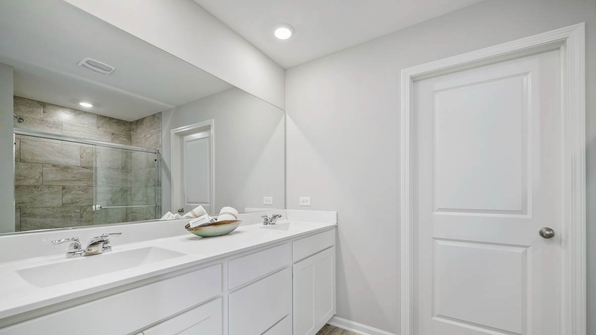 Primary bathroom with dual sinks and walk in closet