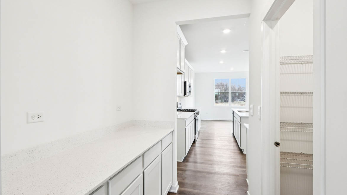 butlers pantry hallway with cabinets and countertop