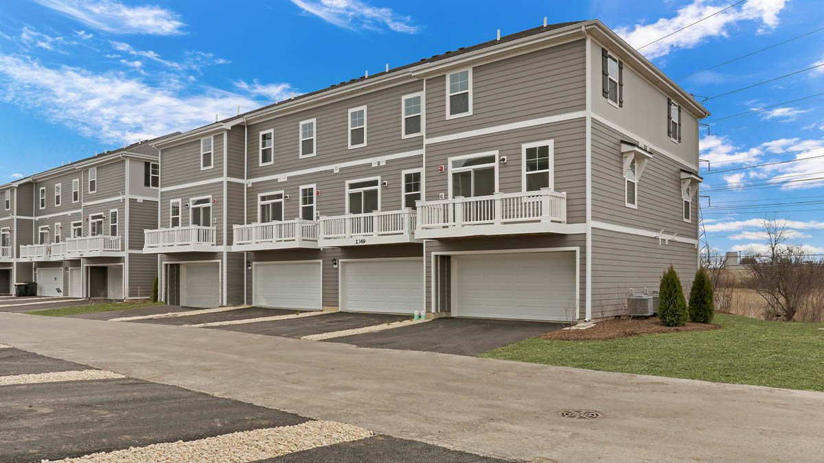 Exterior back of unit with attached 2 car garage and large balcony