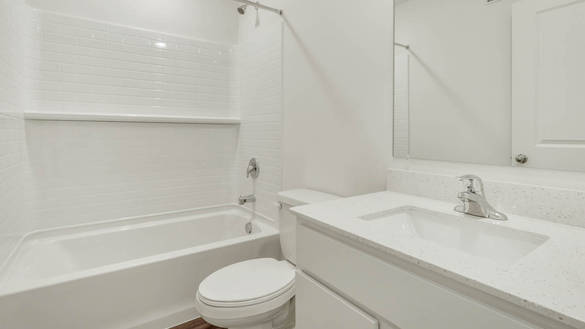 Second bath with built-in tub-shower combo, vanity, sink, lighting, stylish finishes in Stonewater Single Family Ranch