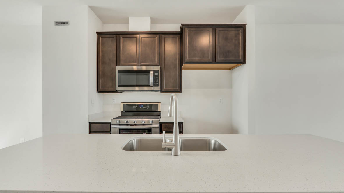Kitchen with flagstone cabinets and white quartz countertops