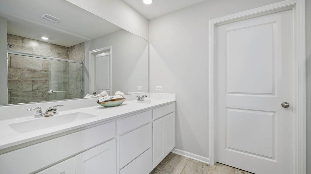 Primary bathroom with dual sinks and walk in closet