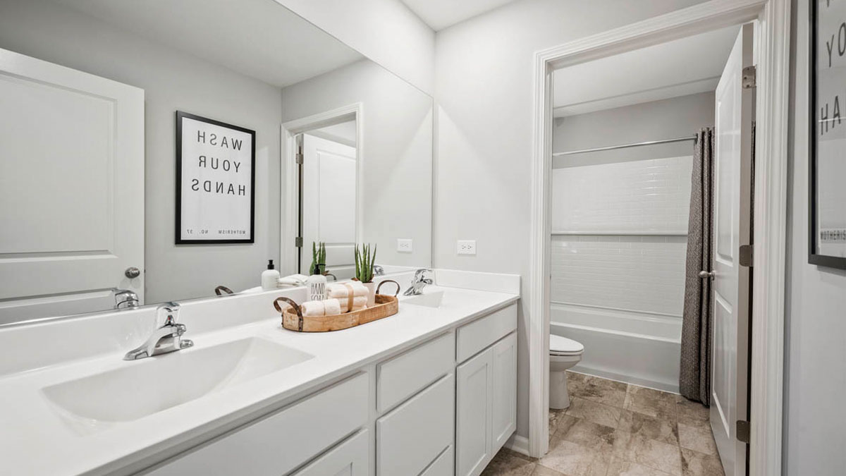 Secondary bathroom with water closet and dual sinks