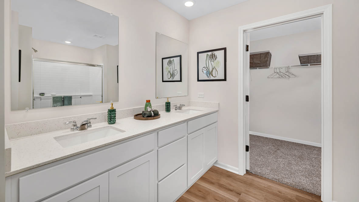 Primary bathroom with dual sinks and walk in closet