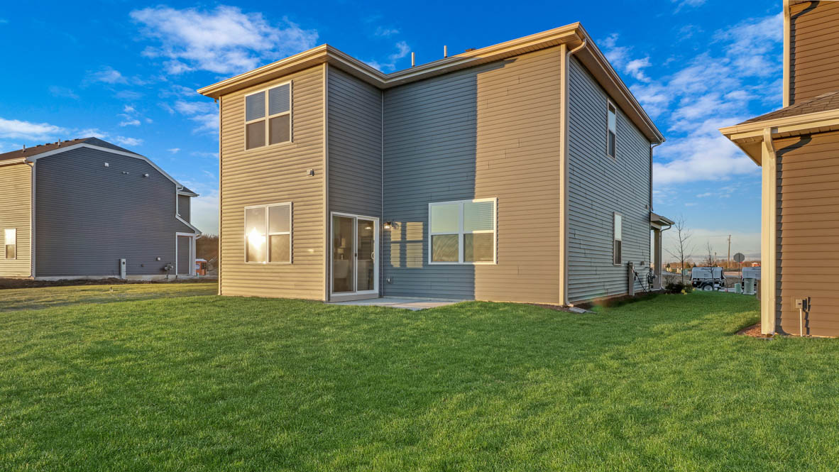 back side of home with patio space and green grass