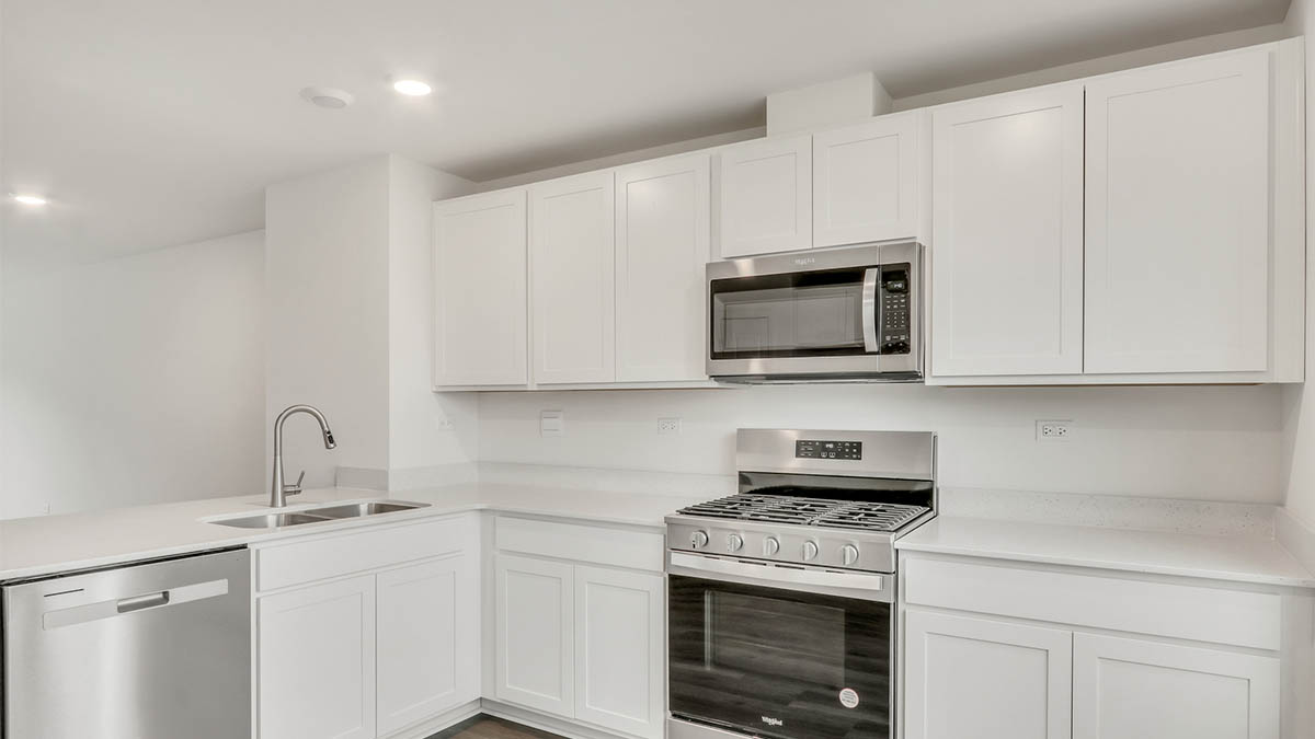 Kitchen with island and light cabinets and stainless steel appliances and stove