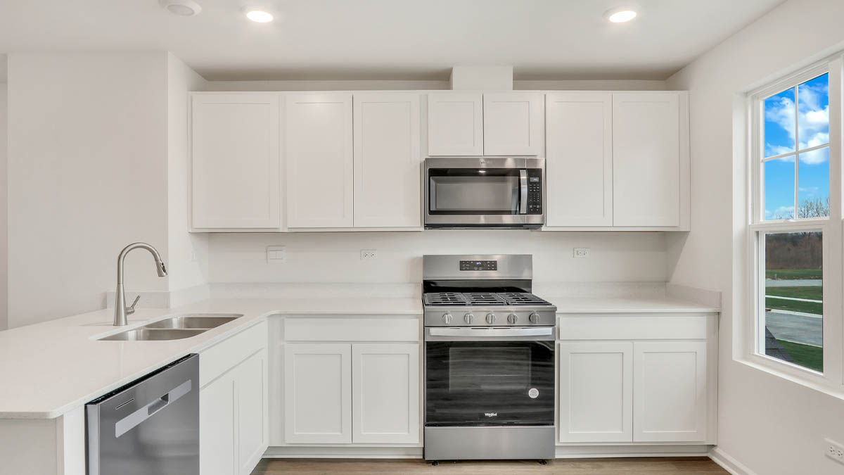 Kitchen with island and light cabinets and stainless steel appliances