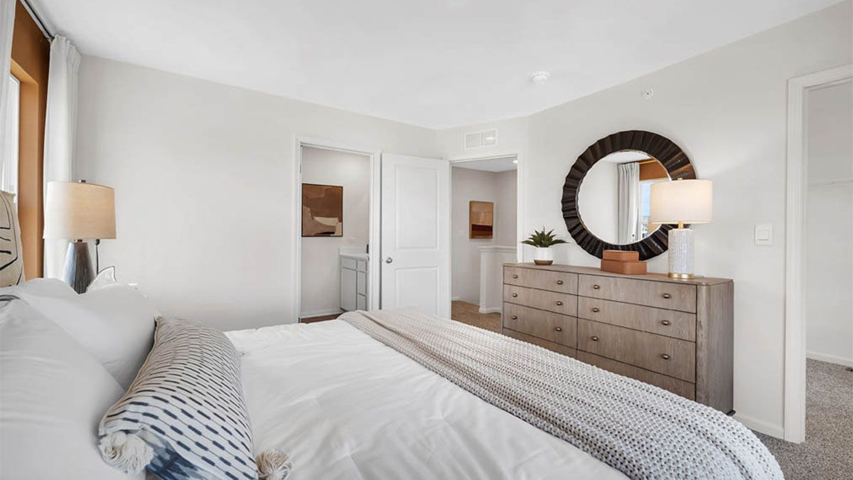 Bedroom with windows and carpeted floors.