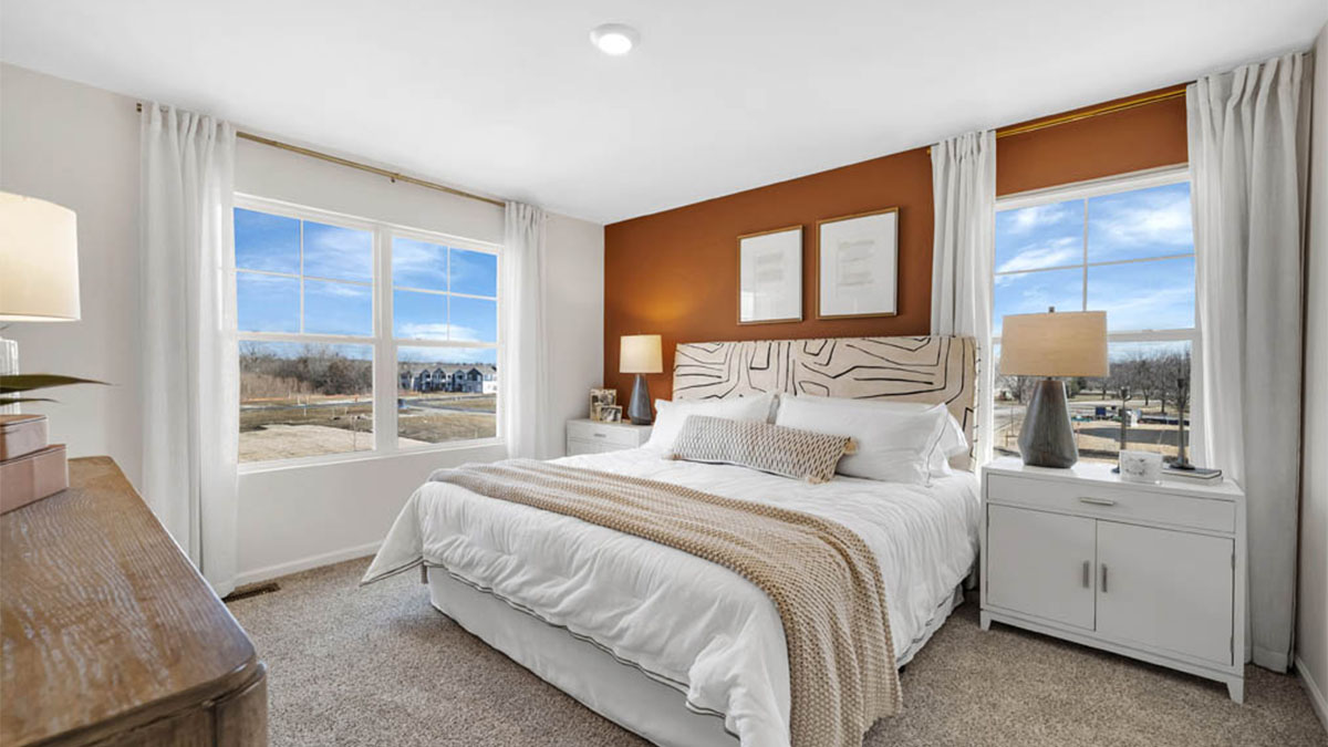 Bedroom with light décor and ceiling fan and red wall