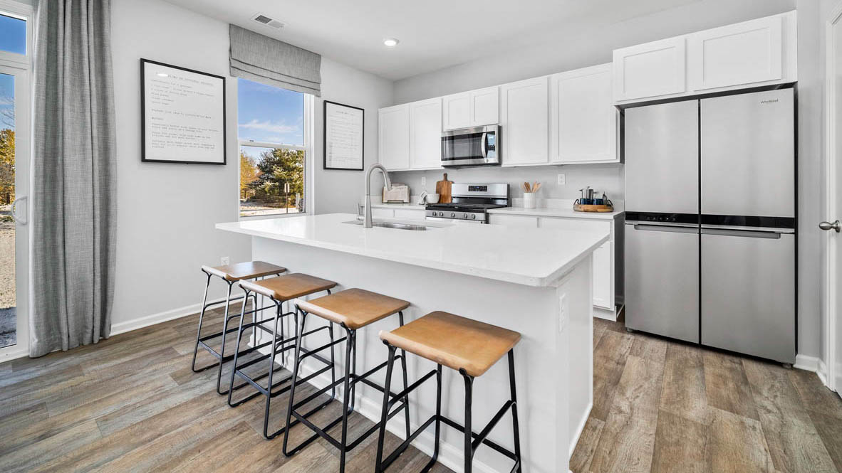 Kitchen with a large island with quartz countertops.