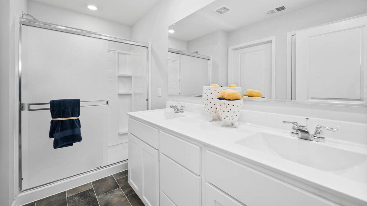 Stonewater Bellamy Model En suite Bathroom with double sinks, quartz countertop, and walk in closet