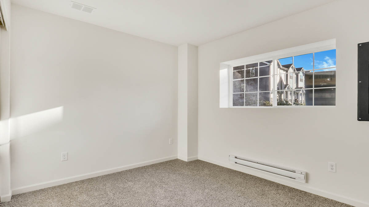 bedroom with beige carpet, white walls and a window