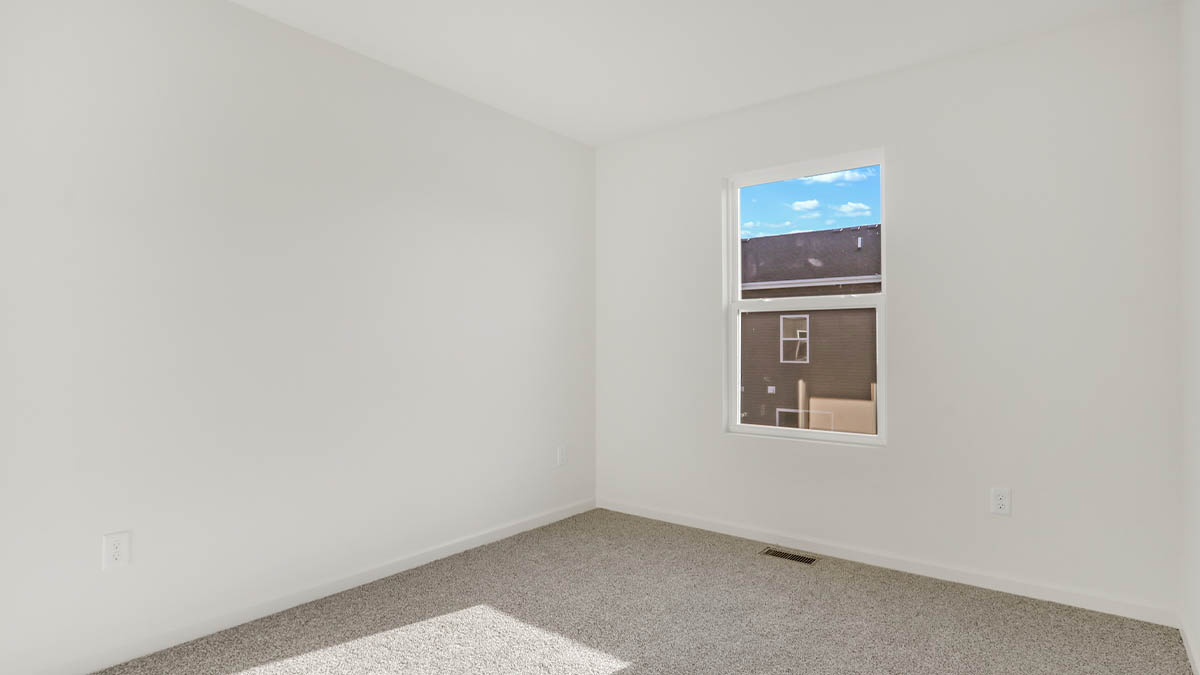 bedroom with beige carpet, white walls and a window