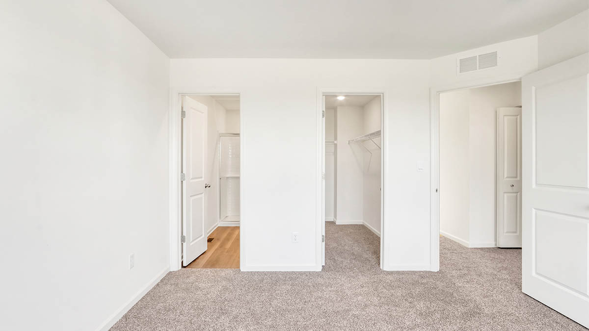bedroom with beige carpet, white walls and a window