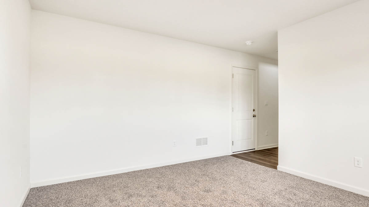 bedroom with beige carpet, white walls and a window