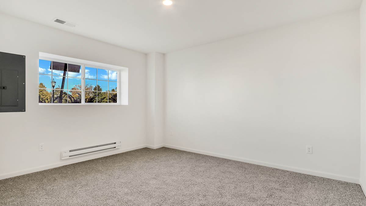 bedroom with beige carpet, white walls and a window