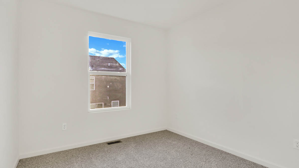 bedroom with beige carpet, white walls and a window