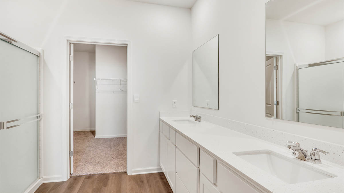 Family bathroom with stylish vanity, mirror, polished fixtures, cabinets, tub-shower combo in Piatt Preserve