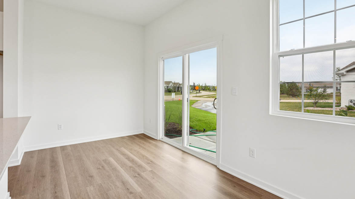 Near concrete patio from sideyard offering access from dining area, grill setup, and a transition from indoor to outdoor living