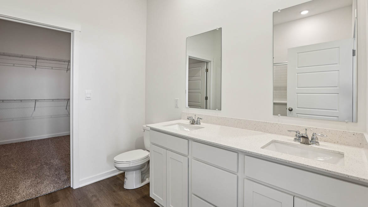 Primary ensuite in D.R. Horton's new townhome featuring an expansive vanity with dual sinks, shower, tub, walk-in closet