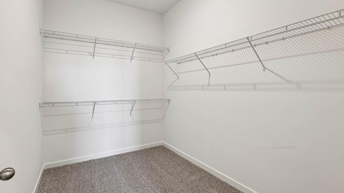 Primary walk-in wardrobe in our new build townhome adds stylish storage and built-in space