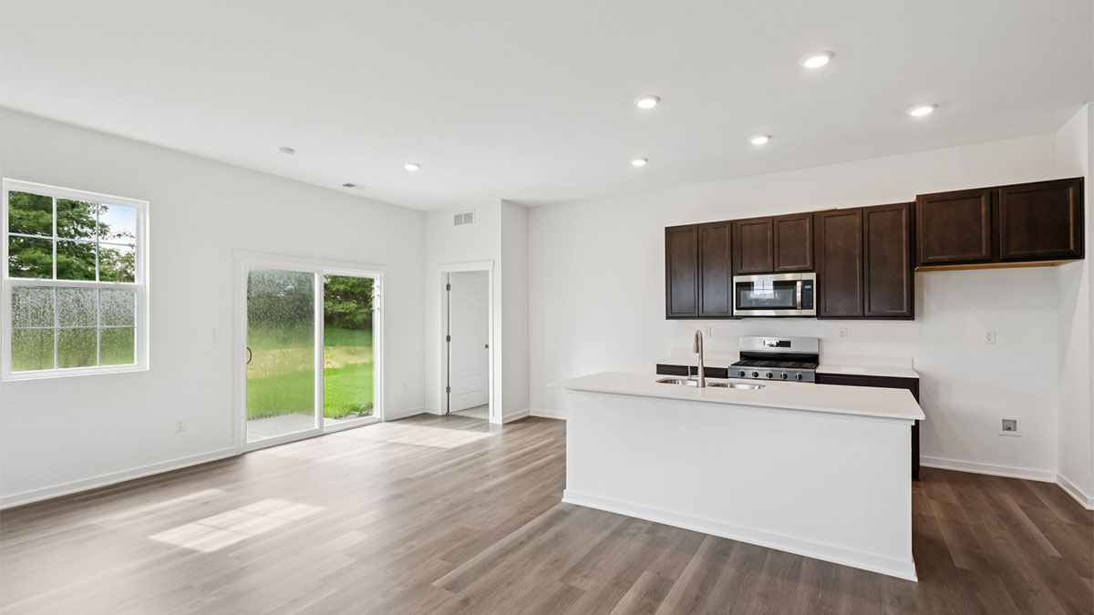 Functional kitchen island adds a sink, multi-prep zones, cabintes and a pantry, new appliance suite, and outside access
