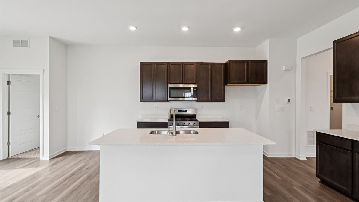Central kitchen island anchors the home adding a dining option, full sink, pantry and storage, multi-prep zones