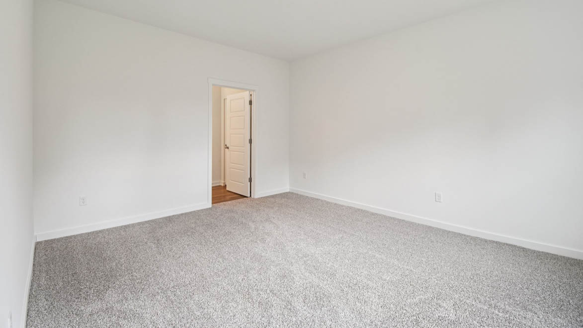 Primary bedroom features ample space, double windows, soft carpet, a stylish walk-in closet, and a private ensuite bath