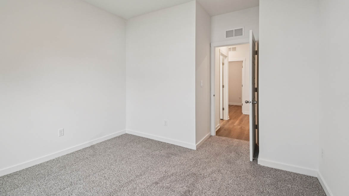 Second bedroom in this new home includes soft carpet, bright window light, closet, ideal for guest or child use