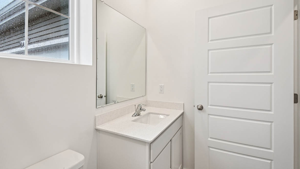Family bathroom with stylish vanity, mirror, polished fixtures, cabinets, tub-shower combo in Stonewater