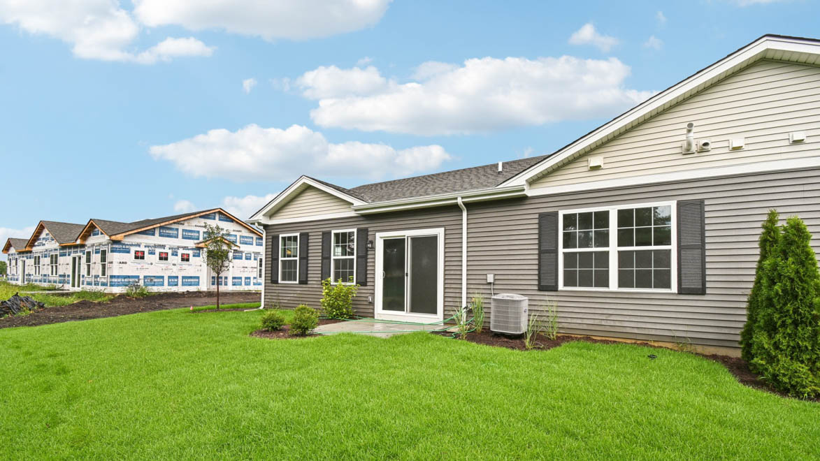 Backyard with concrete patio, grass area adds seating, grill setup, and a transition from indoor to outdoor living
