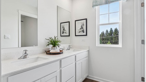 Secondary full bathroom with dual sinks and water closet